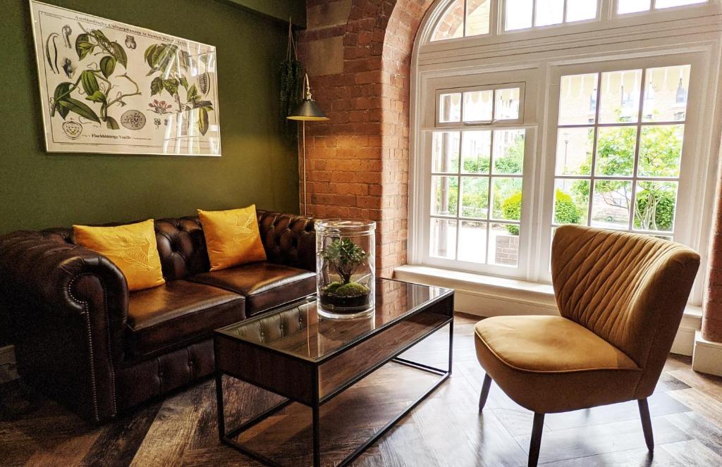 sala de estar con sofá de cuero y mesa de centro en The Botanist's Hideout - Luxury Retreat with Parking, en York