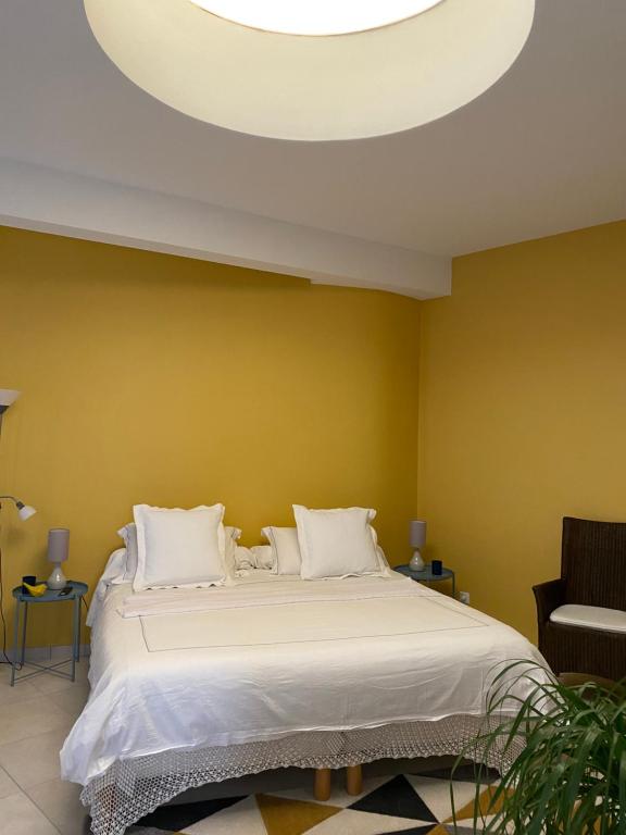 a bedroom with a large bed with a yellow wall at Le Charles VII in Chinon
