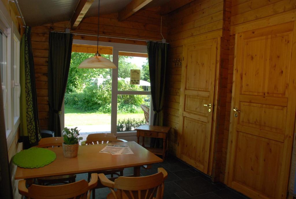 a dining room with a table and a window at Camping "De Stuurmanskolk" in Welsum