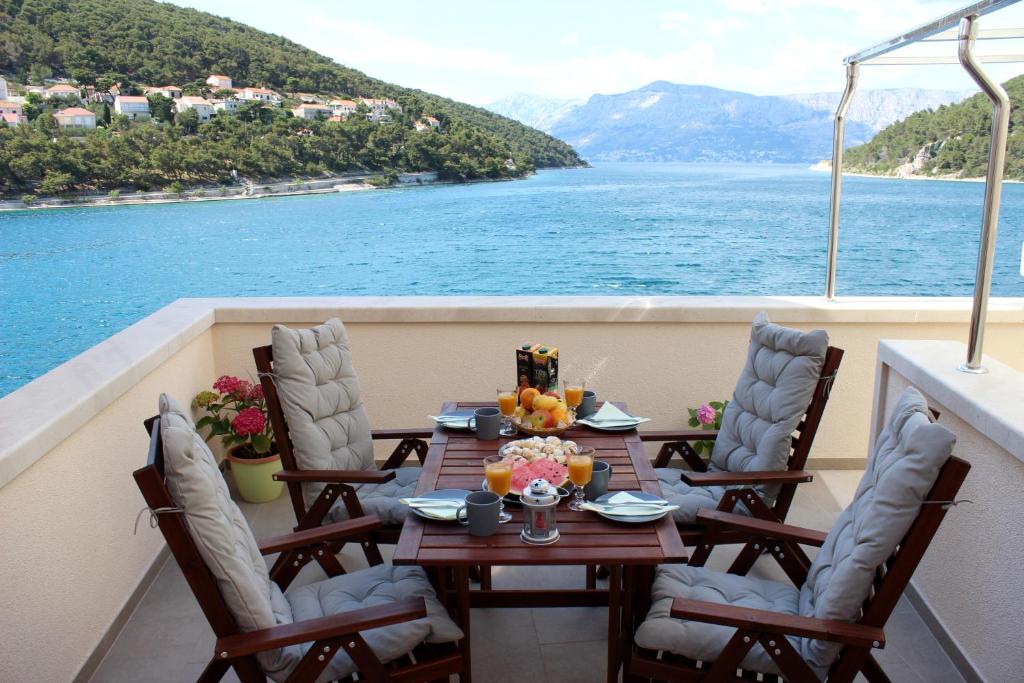 a table on a balcony with a view of the water at THE VIEW in Pučišća