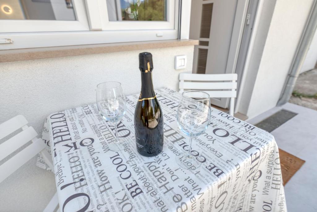 a bottle of wine sitting on a table with glasses at Apartment light in Pula in Pula