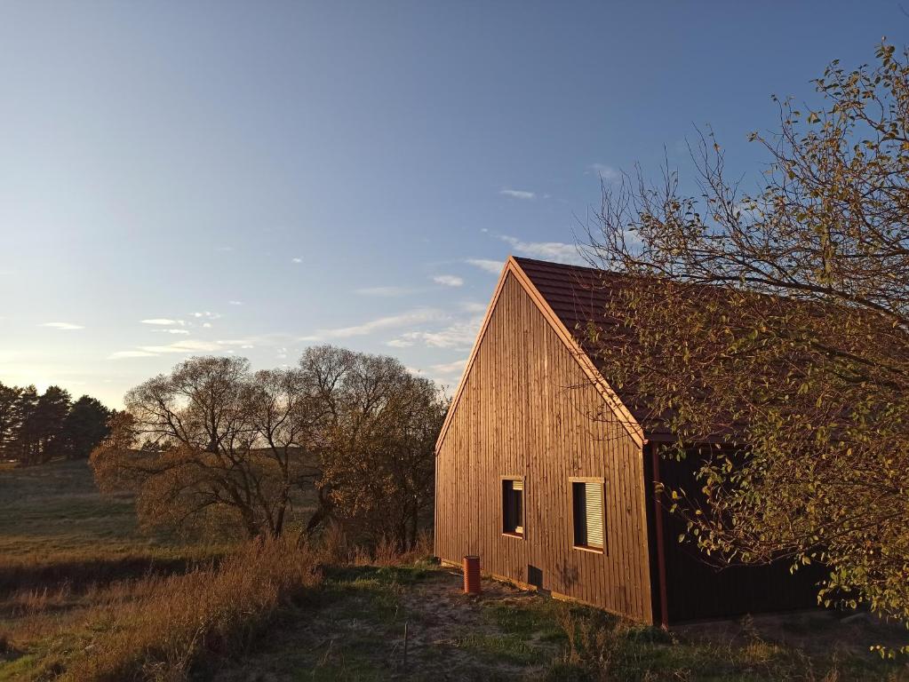 an old red barn sitting in a field at Dom na Mazurach z Widokiem Na Las in Jedwabno