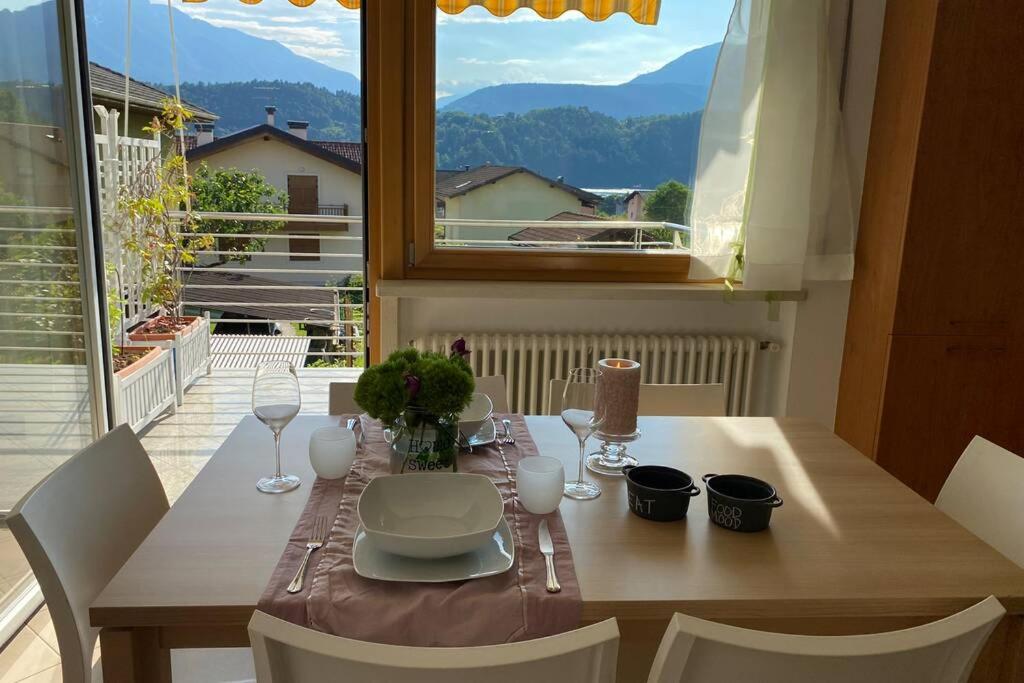 a dining room table with a view of the mountains at Mountain&Lake Apartment - CIPAT: 022104-AT-849776 in Levico Terme