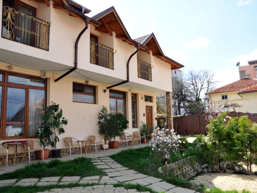 een huis met een patio en een tuin bij Guesthouse Elizabeth in Samokov