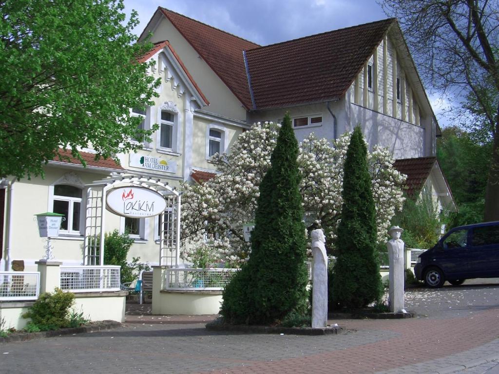 a white building with trees in front of it at Hotel am Deister in Barsinghausen