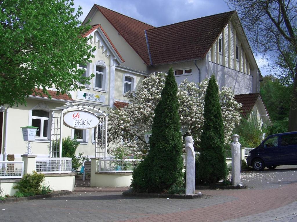 ein weißes Gebäude mit Bäumen davor in der Unterkunft Hotel am Deister in Barsinghausen