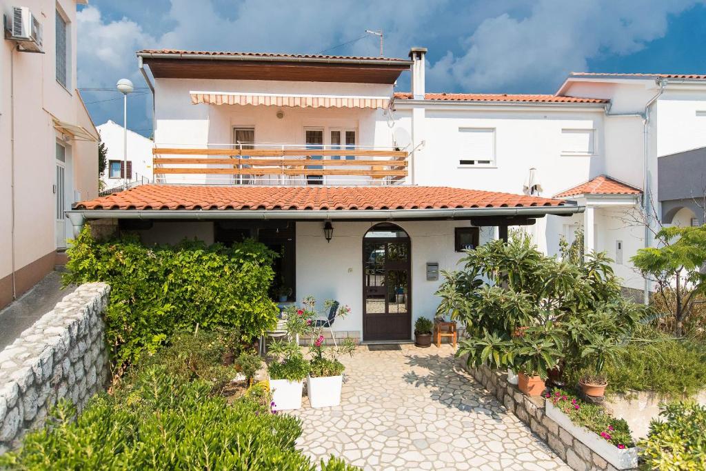 a white house with a courtyard with plants at Apartmani Vera in Crikvenica