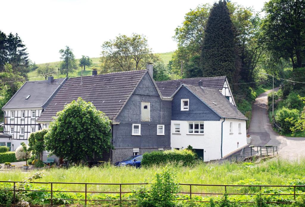 een groot zwart-wit huis op een heuvel bij Bergische Ferienwohnung in Engelskirchen