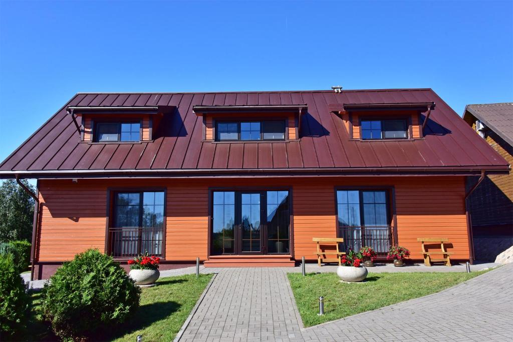 una casa con techo marrón y ventanas en Panorama en Trakai