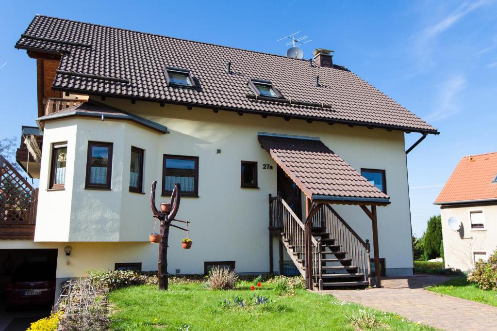 Casa blanca con techo marrón en Ferienwohnung Hetzdorf - Urlaub am Tharandter Wald, en Hetzdorf