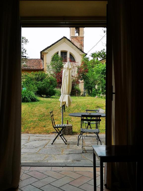 a patio with a table and an umbrella and a table and chairs at La loggia dei frati in Cannero Riviera