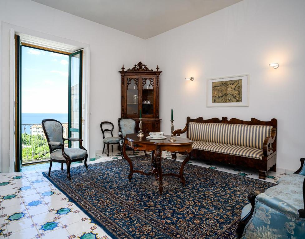 un soggiorno con divano, tavolo e sedie di Amalfi Coast Family Luxury Suite a Vietri