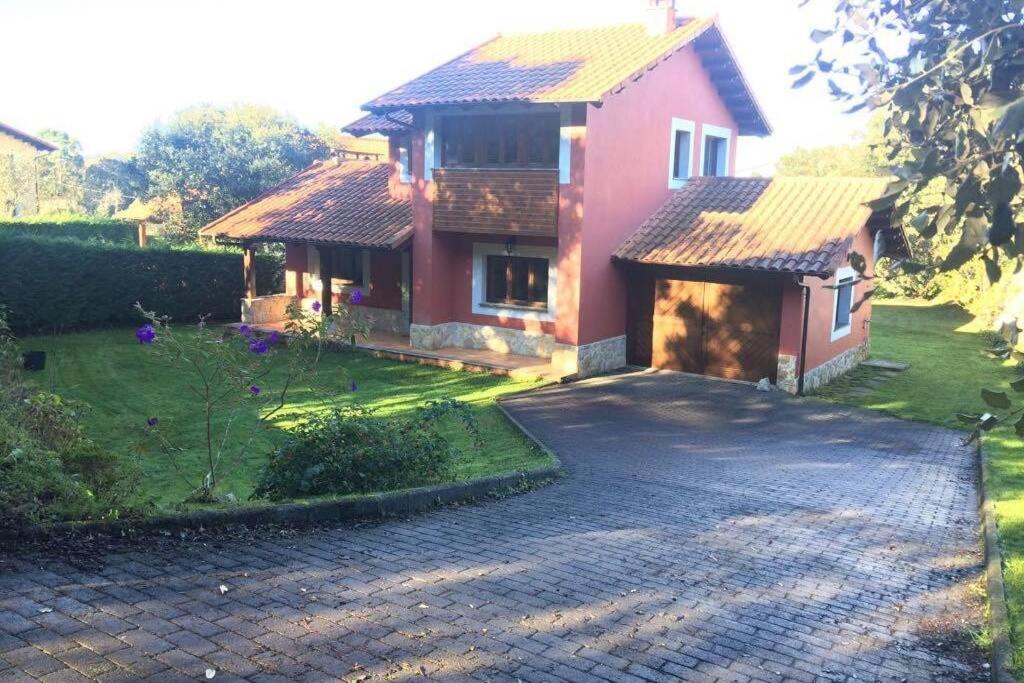 a house with a driveway in front of it at Vivienda vacacional Los Nogales in Llanes