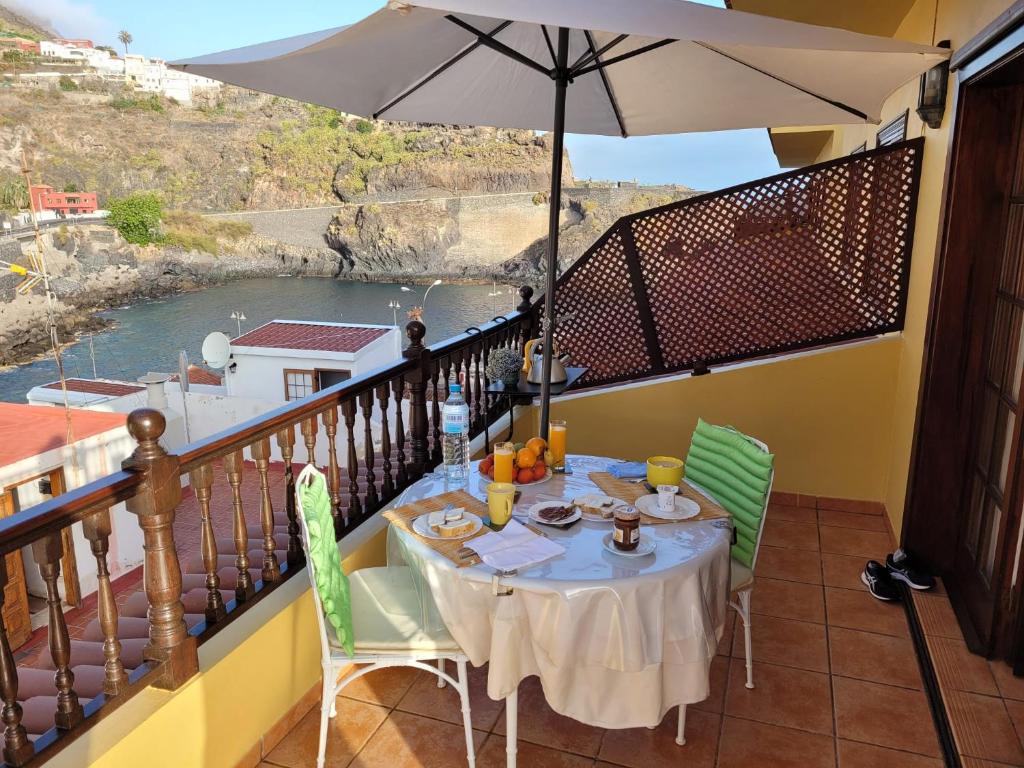 ガラチコにあるMaravilloso Apartamento VISTAS AL MAR Y VOLCANの水辺の景色を望むバルコニー(テーブル付)