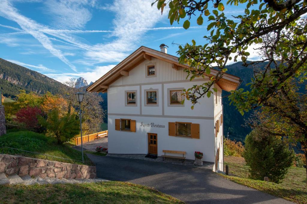 una casa en las montañas con un banco delante en Appartment Kirch Neuhaus, en Laion