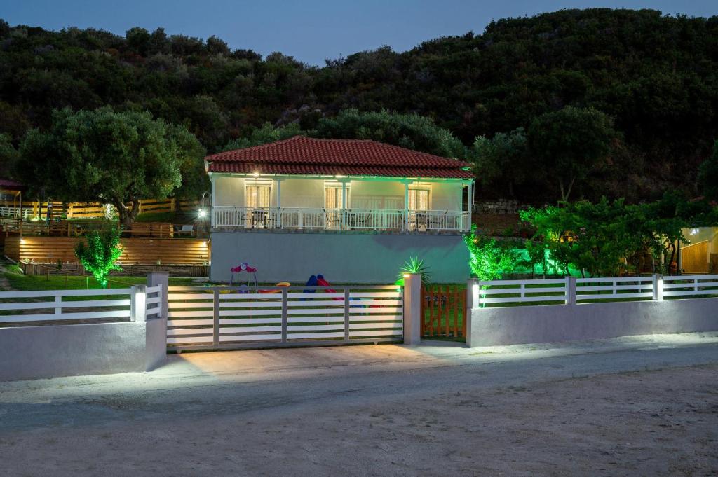 a house with a fence in front of it with lights at Studios Vagelis in Kalamitsi