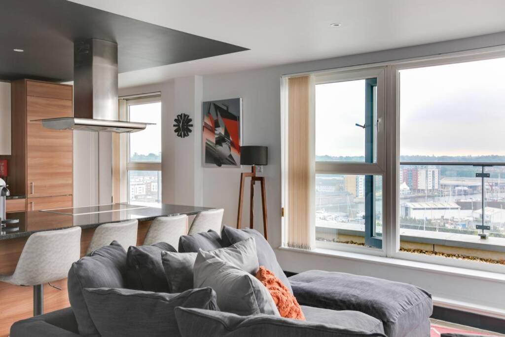 a living room with a couch and some windows at The Marina Penthouse in Ipswich