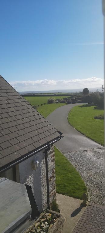 a view of a house with a driveway and a road at Rural Farmhouse in Poughill