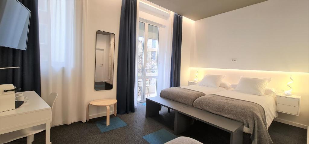 a white bedroom with a bed and a window at PLAZA VIEW in Valencia