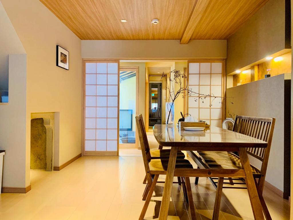 comedor con mesa de madera y sillas en 京町屋の宿 天神庵, en Kioto