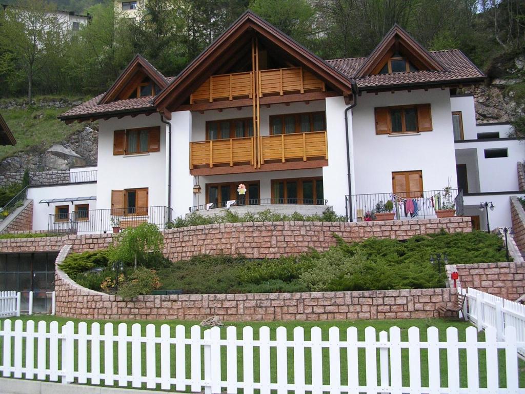 a house with a white fence in front of it at Casa Costa del Sol in Molveno