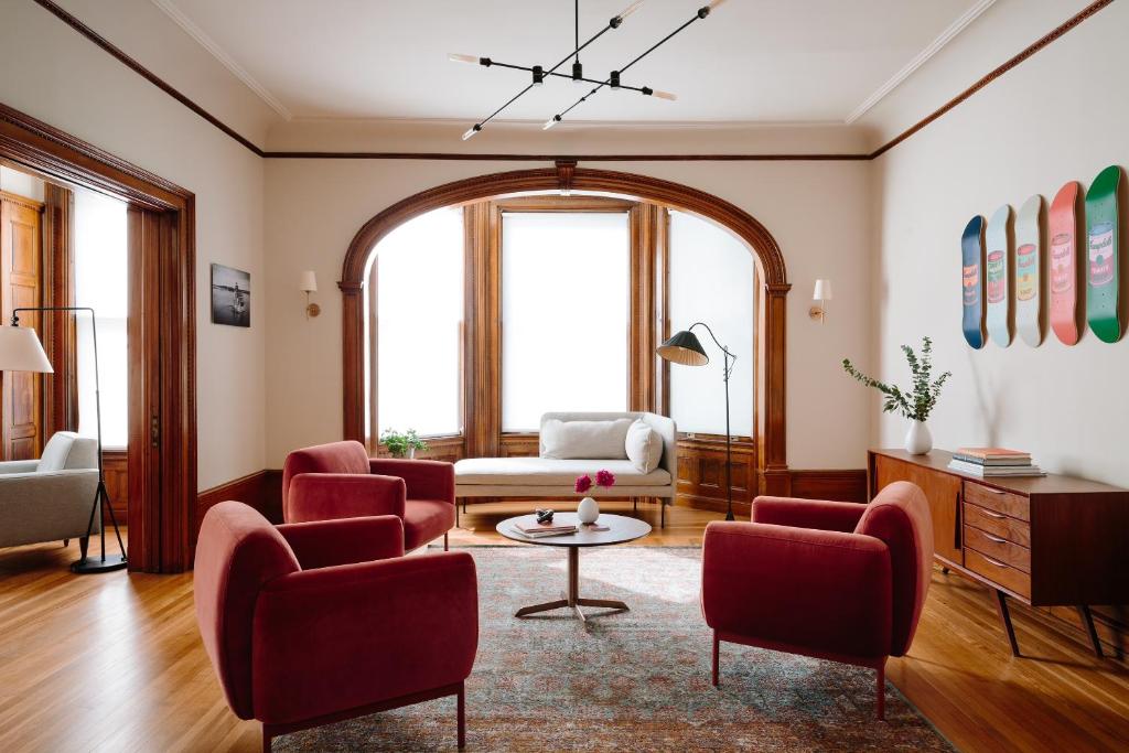 a living room with red chairs and a table at The Amelia in Hudson