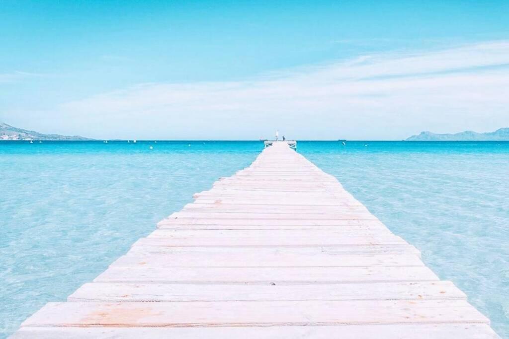 ein hölzerner Pier mitten im Wasser in der Unterkunft Verano ETERNO en Mallorca - Alcudia! in Alcúdia