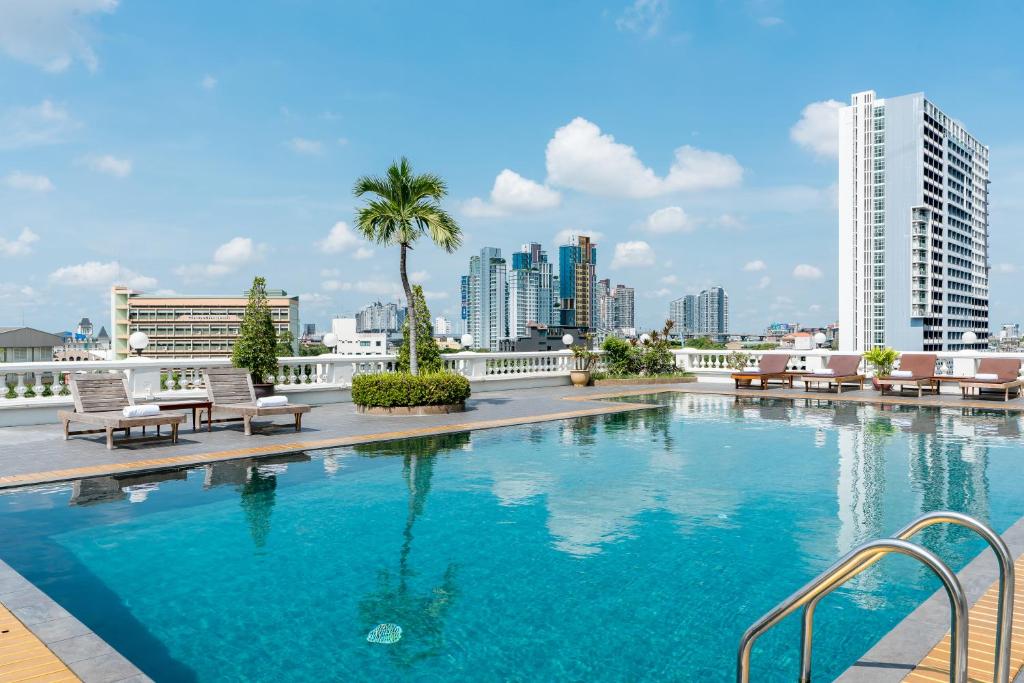 una piscina con vista sullo skyline della città sullo sfondo di Niran Grand Hotel a Bangkok