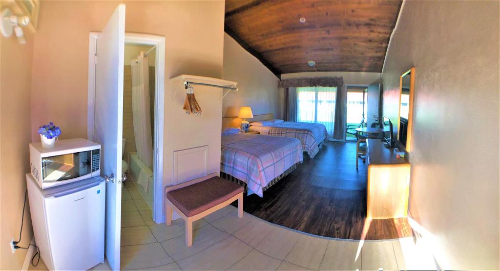 a bedroom with two beds and a door to a room at Hotel Motel Bonsoir in Granby