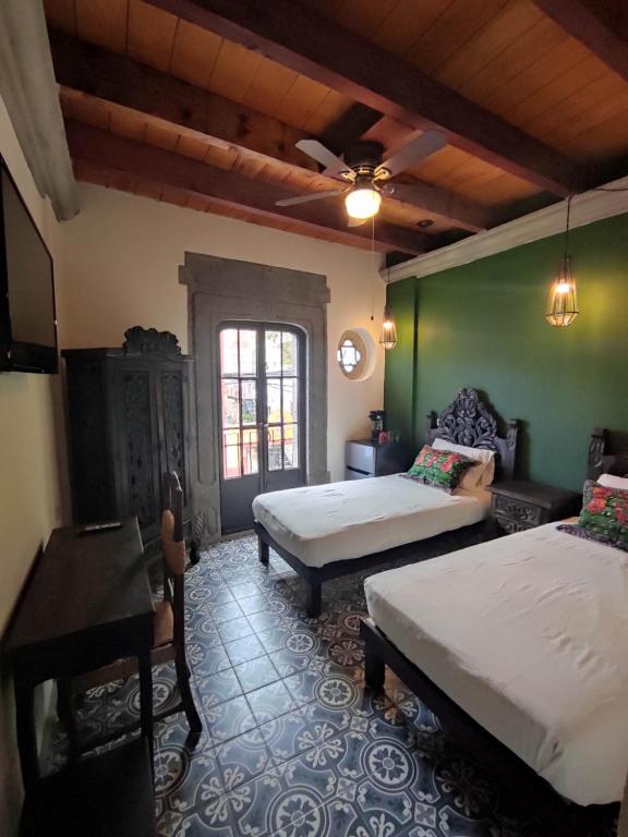 1 dormitorio con 2 camas, mesa y ventana en Nunõ, en San Miguel de Allende