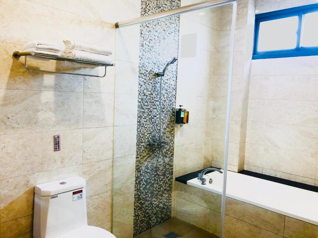 a bathroom with a shower and a toilet and a sink at Weiden House in Luodong