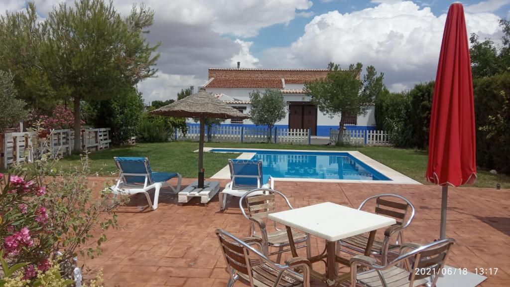Bolaños de Calatrava的住宿－Casa Rural con jacuzzi y pista de padel - Casa de Pacas，一个带桌椅的庭院和一个游泳池