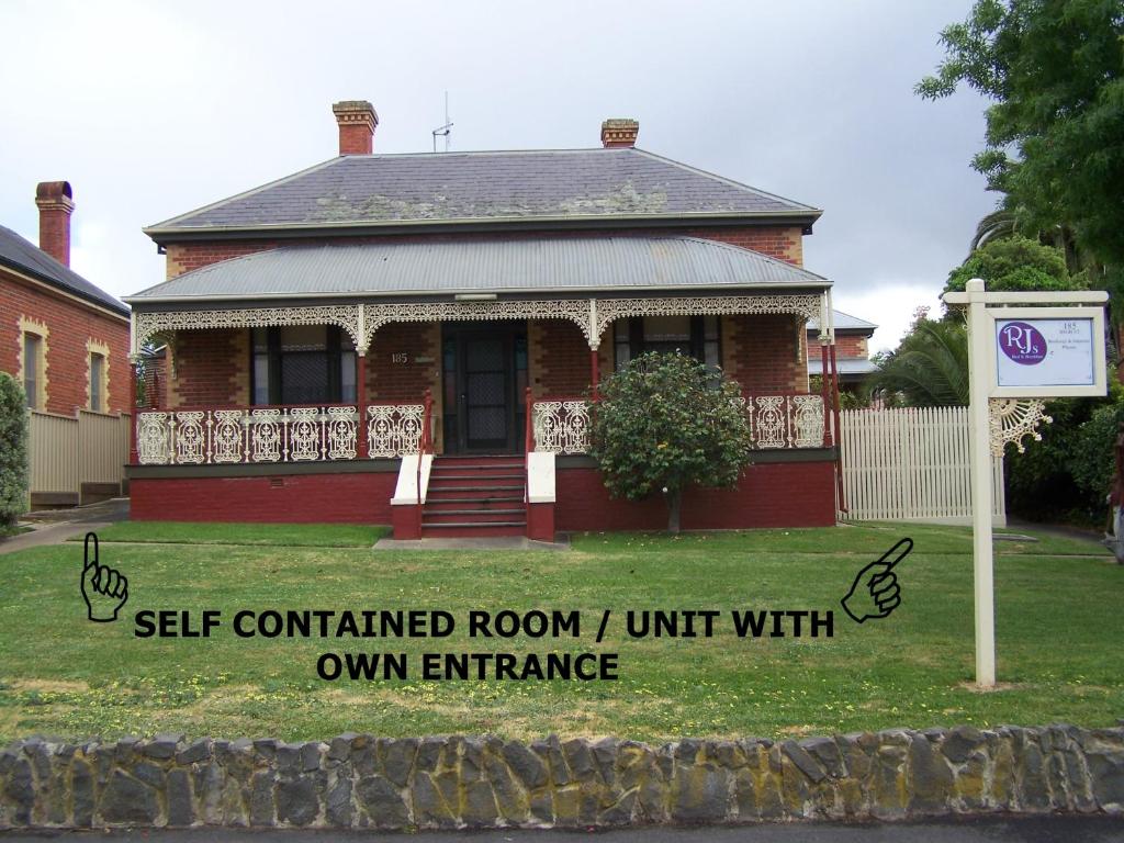 a red brick house with a sign in front of it at RJ's Bed & Breakfast in Maryborough