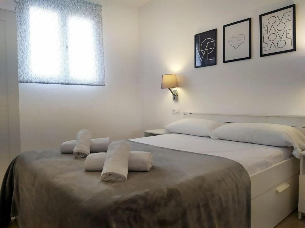 een slaapkamer met een groot bed en handdoeken bij Hermosa casa con piscina cerca de la playa de Punta Prima in Punta Prima