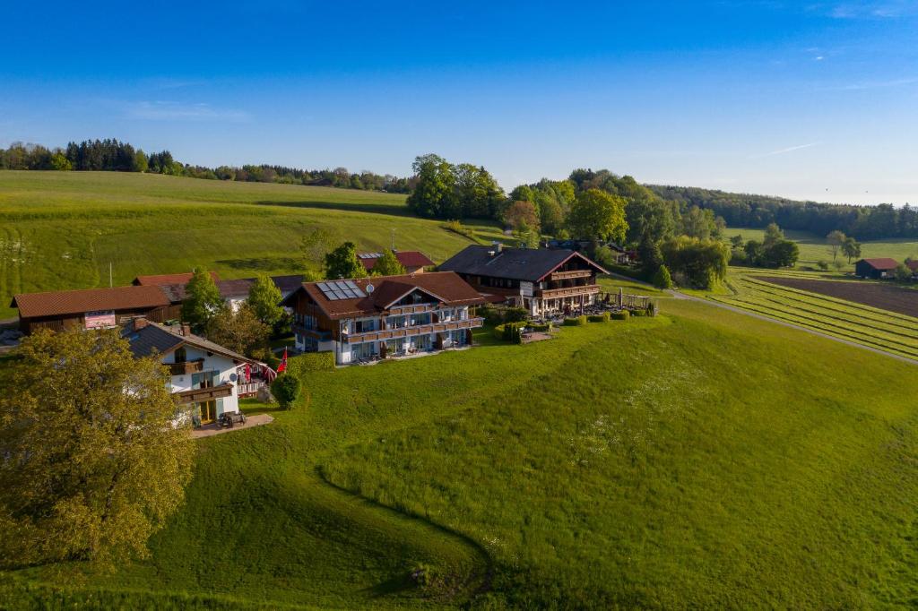 eine Luftansicht eines großen Hauses auf einem grünen Feld in der Unterkunft Berg Hotel Weingarten Garni in Rimsting
