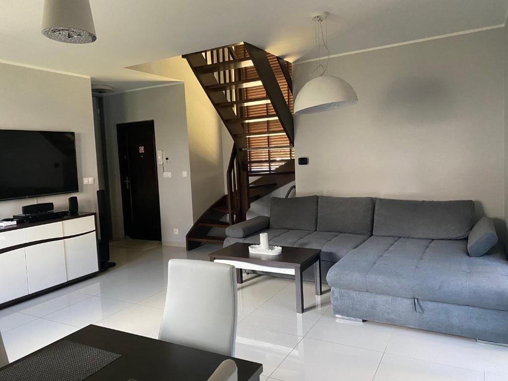 salon z kanapą i stołem w obiekcie Hire House w Pobierowie