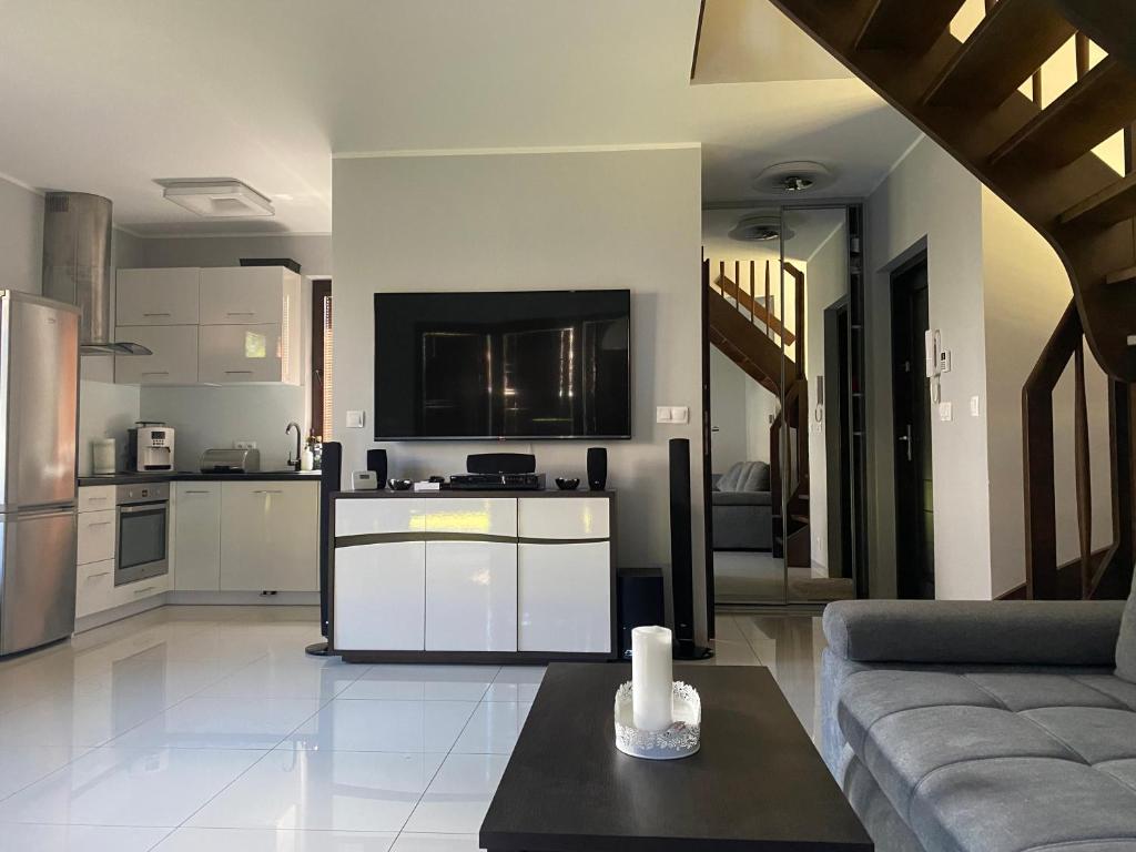 salon z kanapą i kuchnią w obiekcie Hire House w Pobierowie