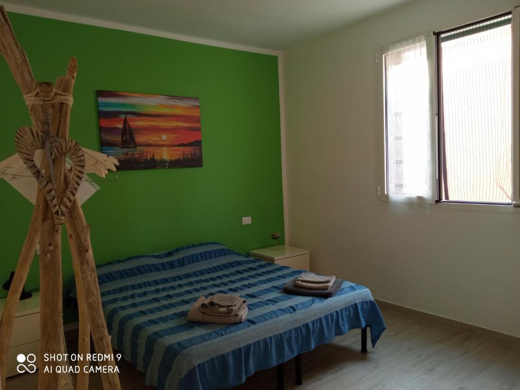 ein Schlafzimmer mit einem Bett und einer grünen Wand in der Unterkunft Verde Mare in Alassio