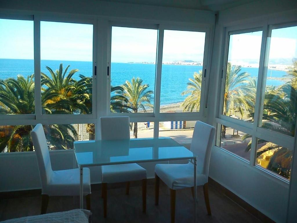 stolik i krzesła w pokoju z widokiem na ocean w obiekcie Estudio sol y playa w mieście Algarrobo-Costa