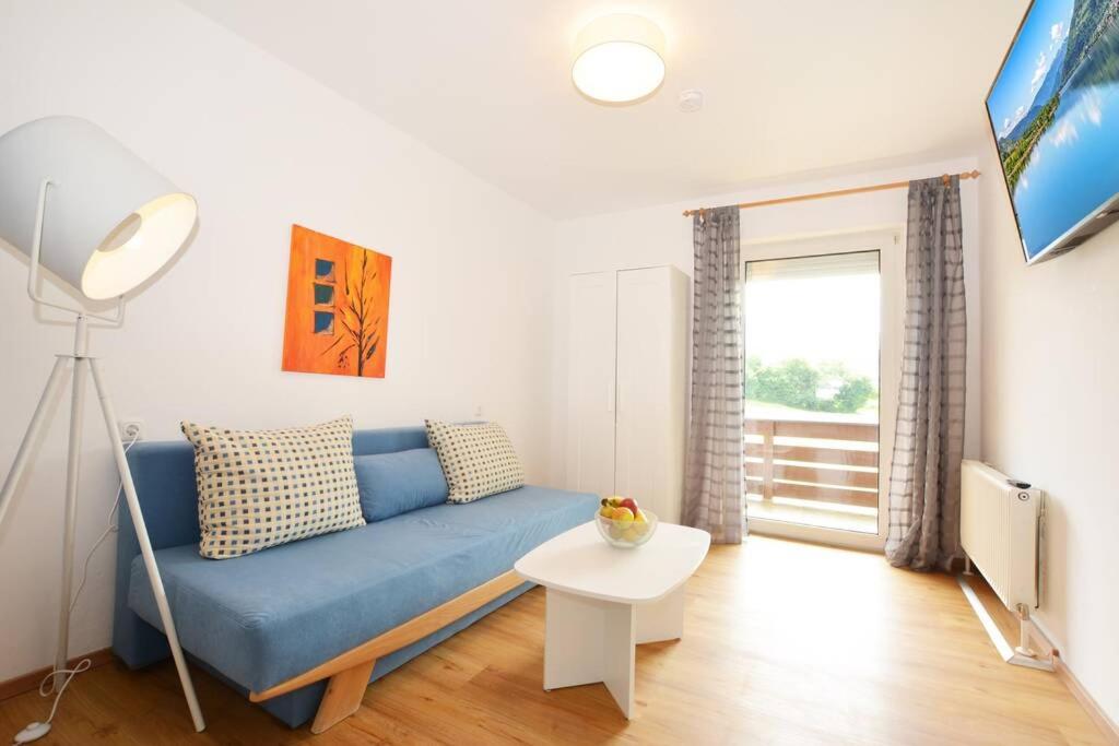 a living room with a blue couch and a table at Sonnige Ferienwohnung mit Balkon in Ruhelage in Villach