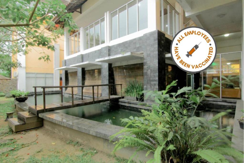 University Hotel في Kalasan: لافته امام مبنى به مسبح