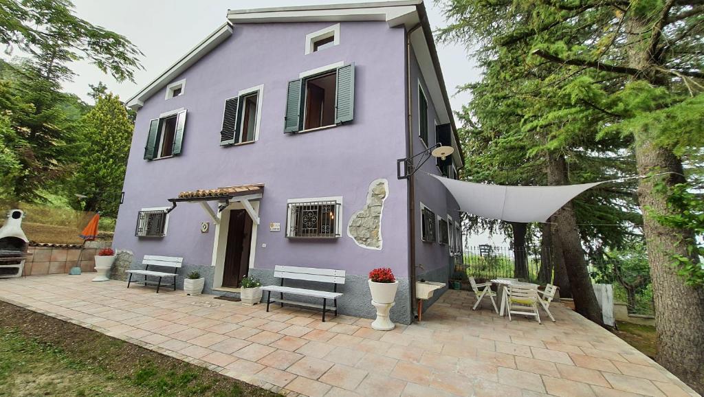 a purple house with a patio in front of it at Flamignano relax e natura in Tossicia