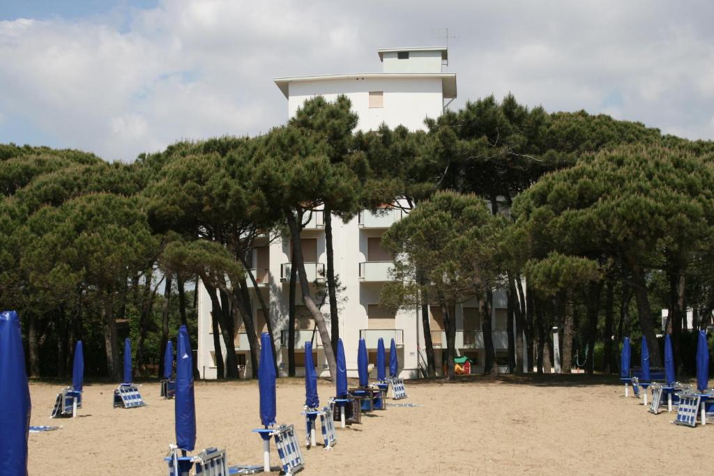 利多迪迪耶索洛的住宿－Appartamenti Ariston，海滩上一群绿树成荫的蓝色椅子