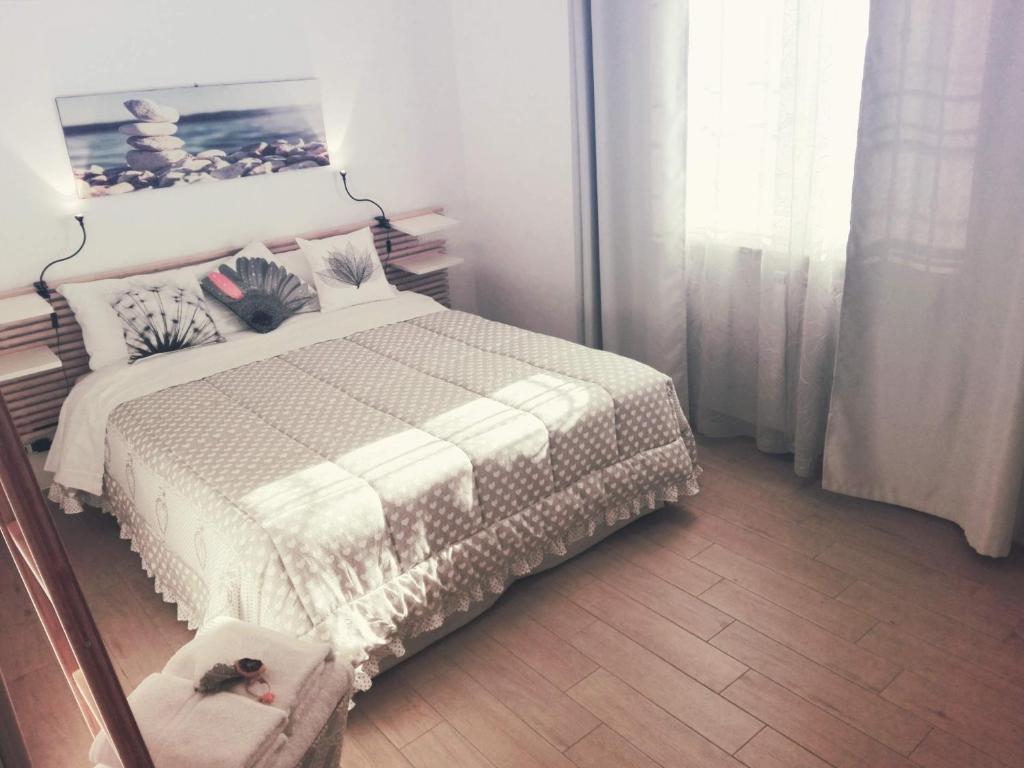 um quarto com uma cama com um edredão branco em L'Angoletto#2 em Ciampino