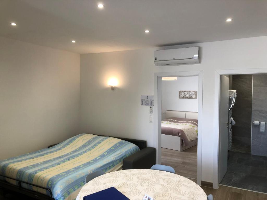 ein kleines Zimmer mit einem Bett und einem Badezimmer in der Unterkunft Sollaris Appartement 1ère étage à 11km de Europa-Park in Friesenheim