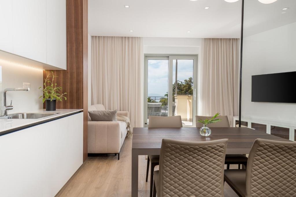 a kitchen and a dining room with a table and chairs at Plaza Apartments in Opatija