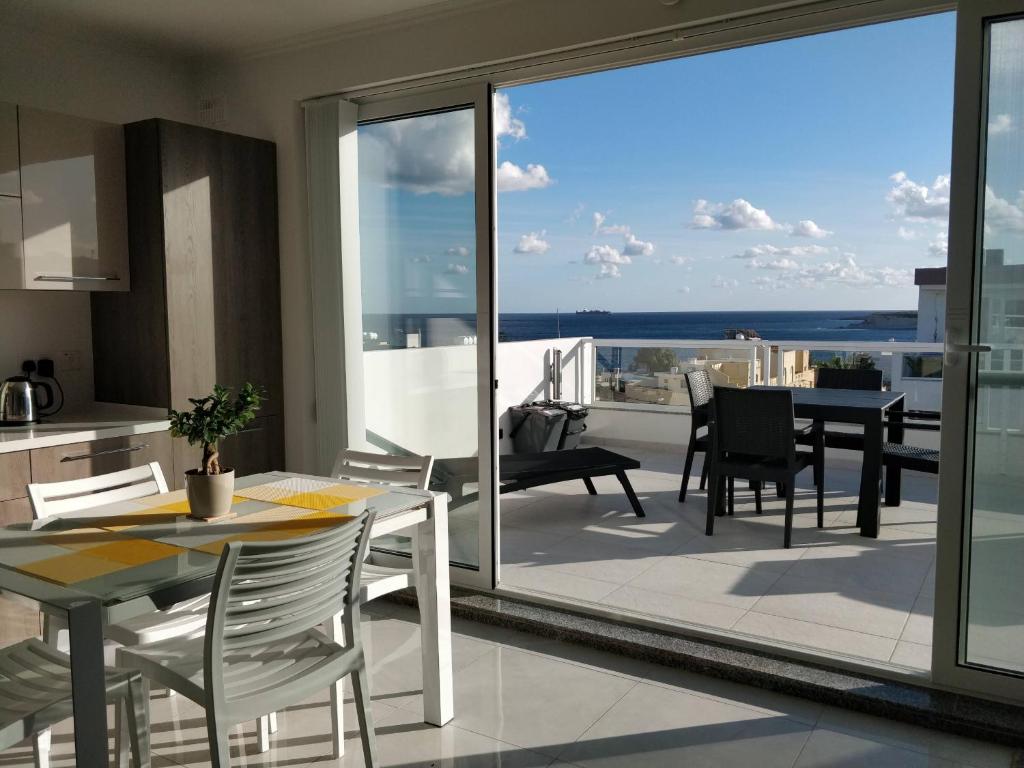 uma cozinha e sala de jantar com vista para o oceano em Sea View Penthouse with large terrace IROM1-1 em Marsaskala