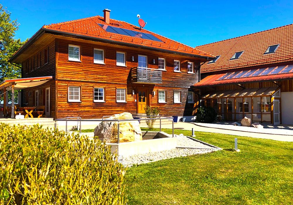 ein großes Holzgebäude mit rotem Dach in der Unterkunft Kraftplatz Waldzell 