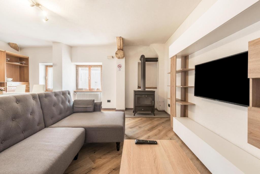 uma sala de estar com um sofá e uma televisão de ecrã plano em Appartamento Glolo 2 em San Lorenzo in Banale