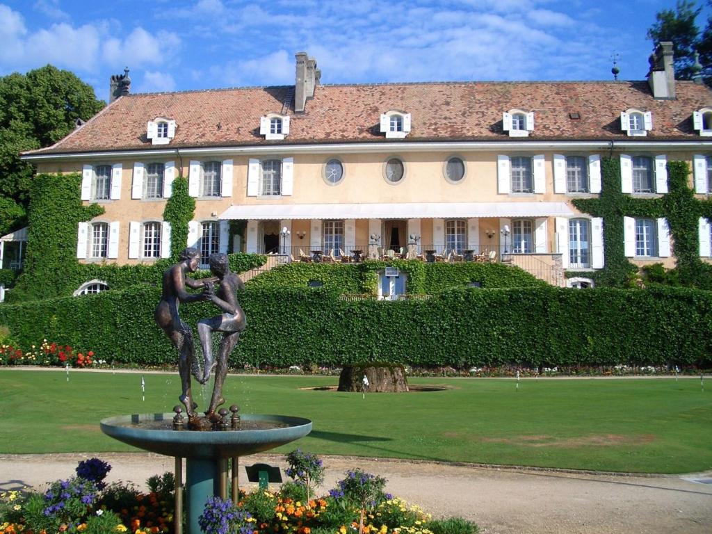 a statue of a girl in front of a building at Château de Bonmont in Cheserex